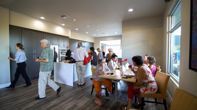 dining area featuring a healthy amount of sunlight, dark wood-type flooring, visible vents, and recessed lighting