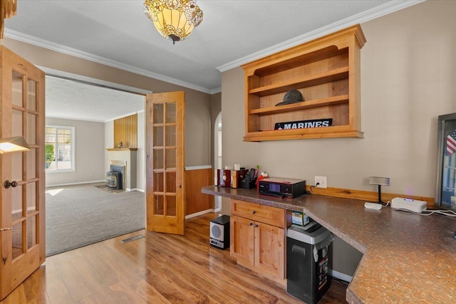 office space featuring built in study area, visible vents, ornamental molding, french doors, and light wood-type flooring