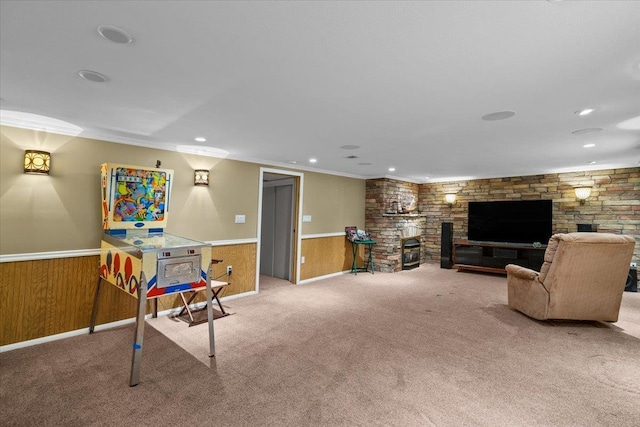 carpeted living area with a fireplace, recessed lighting, ornamental molding, and wainscoting