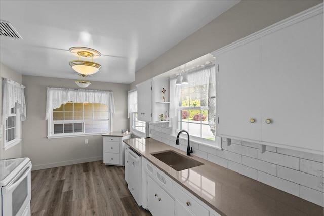kitchen with white appliances, a sink, backsplash, and white cabinetry