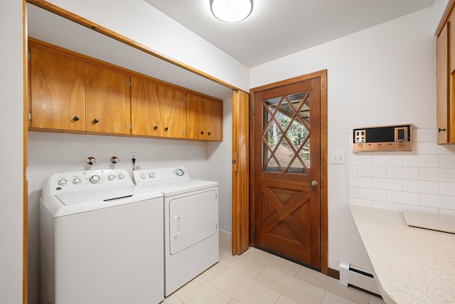 washroom featuring baseboard heating, independent washer and dryer, light tile patterned floors, and cabinet space