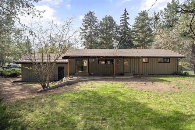 back of house featuring a lawn and board and batten siding
