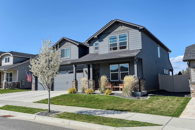 craftsman-style home with concrete driveway, an attached garage, fence, a porch, and a front yard