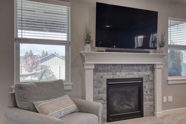 interior space featuring baseboards, a brick fireplace, and carpet