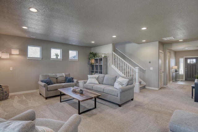 living area featuring recessed lighting, a textured ceiling, and light colored carpet