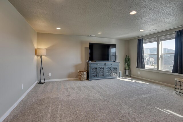 unfurnished living room with recessed lighting, carpet, a textured ceiling, and baseboards