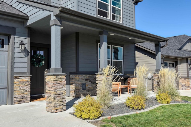 entrance to property with a porch and stone siding