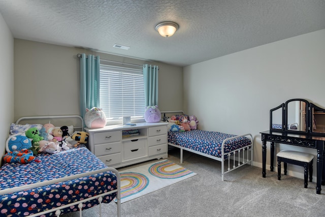bedroom featuring a textured ceiling, visible vents, and light carpet