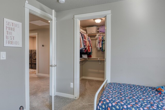 carpeted bedroom with a walk in closet, washer and dryer, baseboards, and a closet