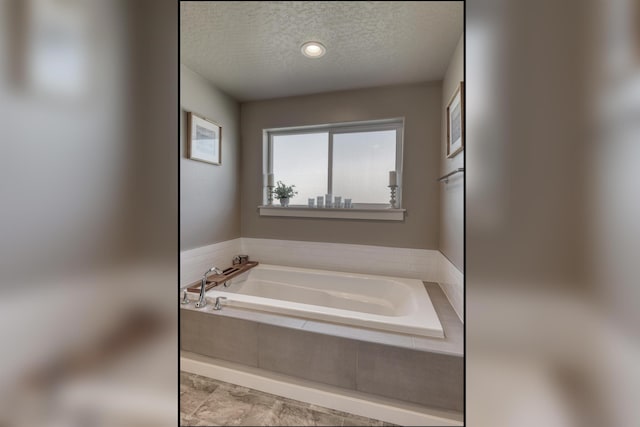 full bathroom with a bath and a textured ceiling