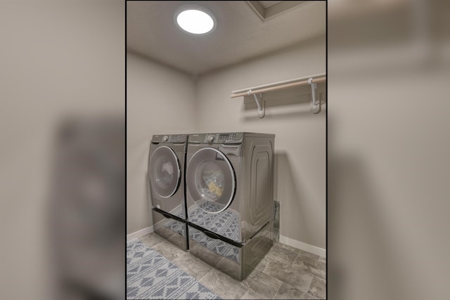 laundry area with baseboards, washer and dryer, and laundry area