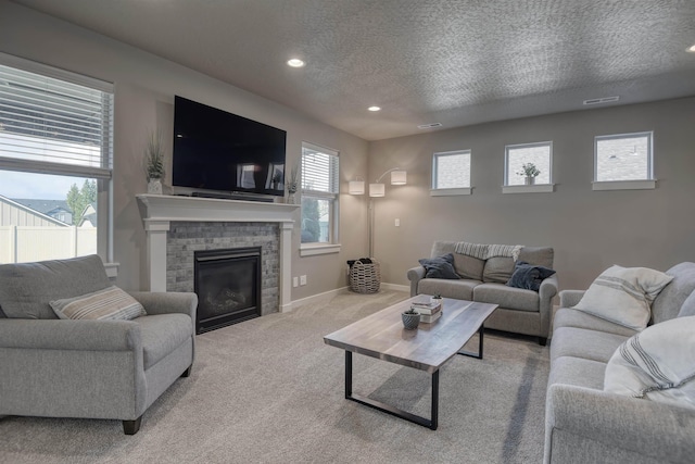 living area featuring a textured ceiling, baseboards, recessed lighting, carpet, and a fireplace