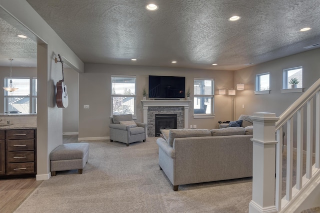 living room with plenty of natural light, a textured ceiling, and stairs