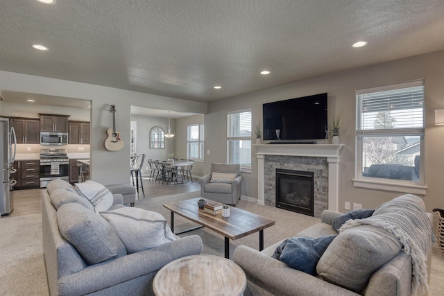 living area featuring recessed lighting, a textured ceiling, and light colored carpet