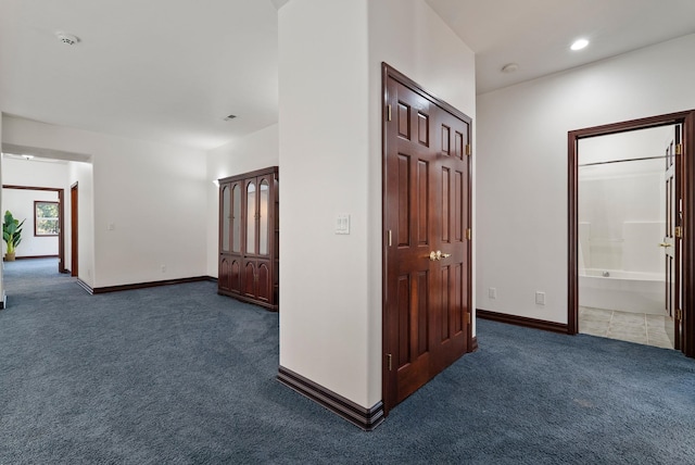 hallway with dark carpet, baseboards, and recessed lighting