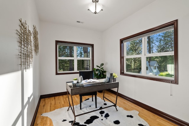 office with a wealth of natural light, light wood-style flooring, visible vents, and baseboards