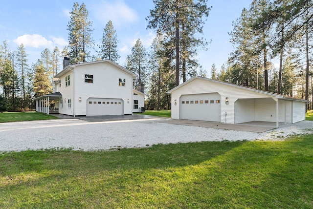 view of side of home featuring a lawn, an outdoor structure, a chimney, and a garage