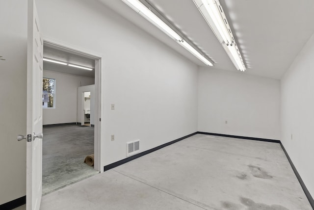 empty room featuring concrete flooring, visible vents, and baseboards