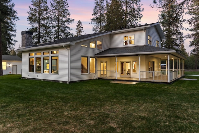 rear view of house featuring a chimney, french doors, and a yard