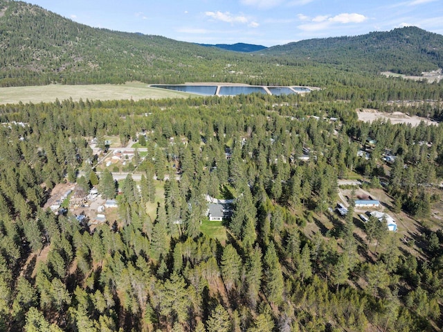 aerial view featuring a water and mountain view and a wooded view