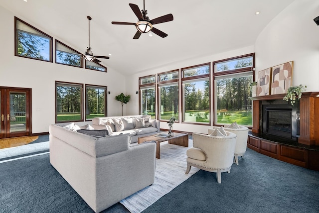 carpeted living area featuring a ceiling fan, a glass covered fireplace, high vaulted ceiling, and recessed lighting