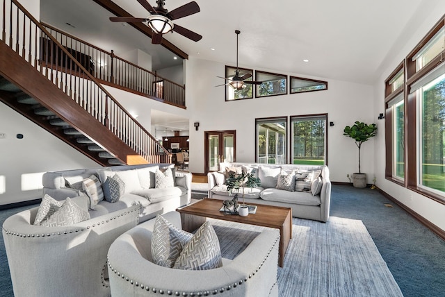 living area with baseboards, a wealth of natural light, a ceiling fan, and carpet