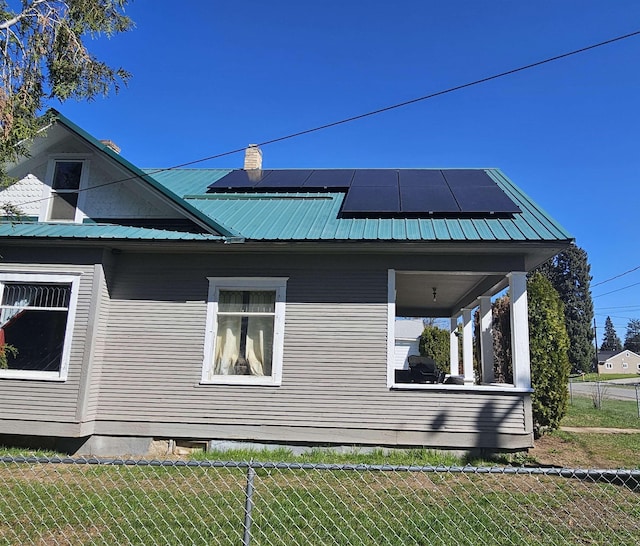303 N Vernon St, Deer Park, WA 99006 - view of side of property with metal roof, solar panels, a lawn, and fence