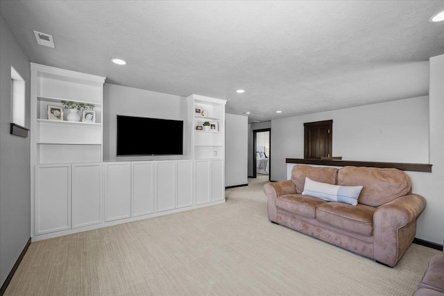living room featuring recessed lighting, a textured ceiling, baseboards, and light carpet