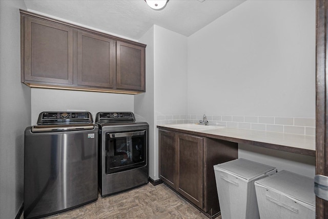 clothes washing area with separate washer and dryer, cabinet space, and a sink