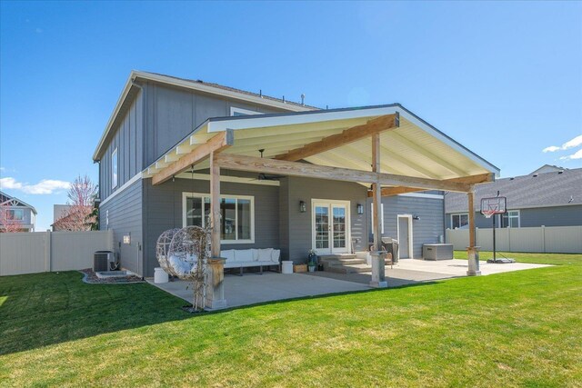 rear view of property with a patio area, a lawn, central AC unit, and fence