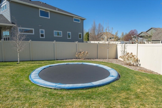 view of yard with fence and a trampoline