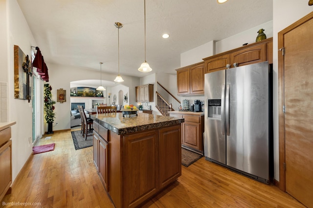 17202 E Morningside Ln, Greenacres, WA 99037 - kitchen with stainless steel fridge with ice dispenser, dark countertops, light wood-style floors, a center island, and hanging light fixtures