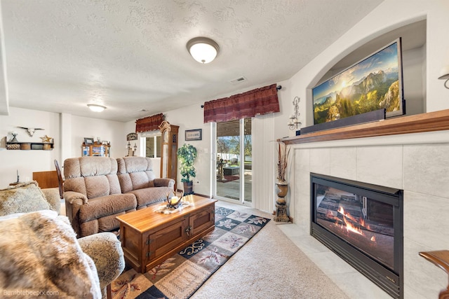 17202 E Morningside Ln, Greenacres, WA 99037 - living area with a tile fireplace, a textured ceiling, tile patterned flooring, and visible vents