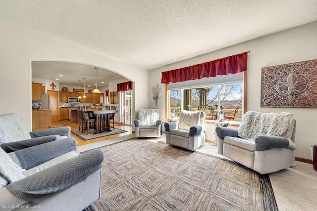 17202 E Morningside Ln, Greenacres, WA 99037 - living area featuring a textured ceiling, arched walkways, light carpet, baseboards, and recessed lighting