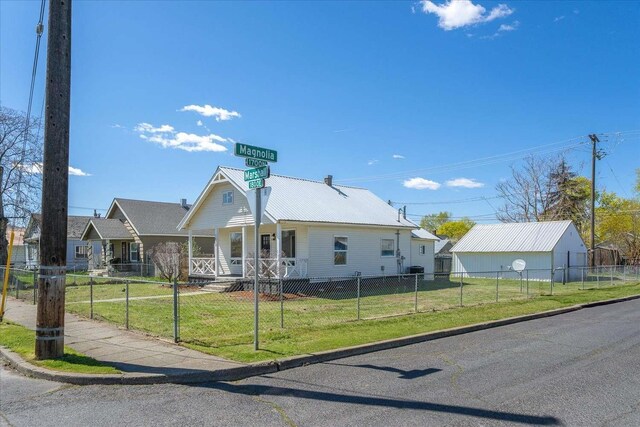 1873 E Marshall Ave, Spokane, WA 99207 - view of front of home featuring metal roof, a front lawn, covered porch, and a fenced front yard