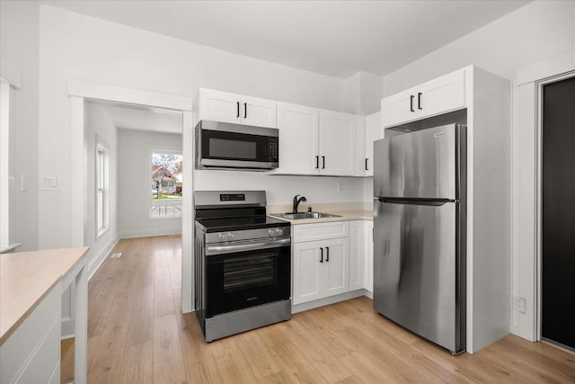 1873 E Marshall Ave, Spokane, WA 99207 - kitchen featuring white cabinets, light countertops, a sink, and appliances with stainless steel finishes