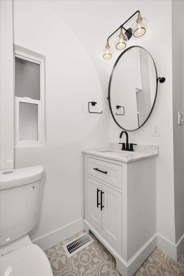 1873 E Marshall Ave, Spokane, WA 99207 - half bathroom featuring vanity, toilet, baseboards, and visible vents