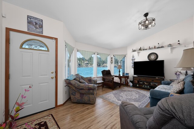 living area featuring vaulted ceiling and light wood finished floors