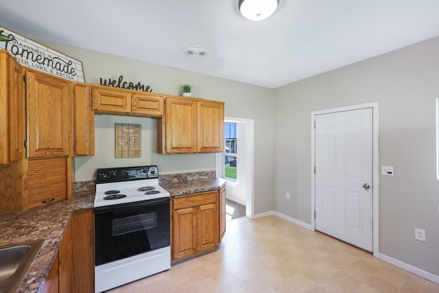 8323 W Mission Ave, Spokane, WA 99224 - kitchen featuring brown cabinets, electric range oven, baseboards, and light floors