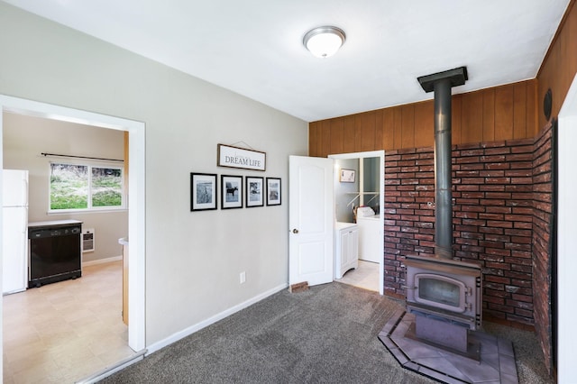8323 W Mission Ave, Spokane, WA 99224 - unfurnished living room with wooden walls, baseboards, and a wood stove