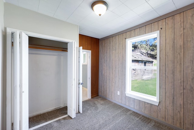 8323 W Mission Ave, Spokane, WA 99224 - unfurnished bedroom with wooden walls, baseboards, carpet, and a closet