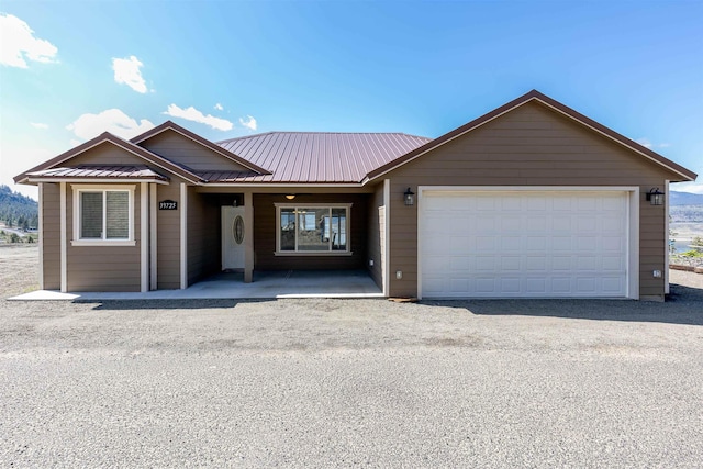 single story home featuring a garage and metal roof