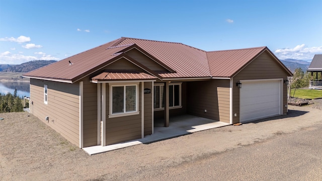 single story home featuring an attached garage, a mountain view, and metal roof