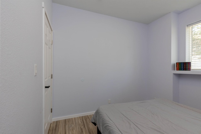 bedroom featuring wood finished floors and baseboards