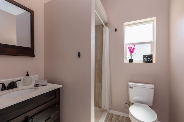 full bathroom featuring wood finished floors, vanity, toilet, and a stall shower