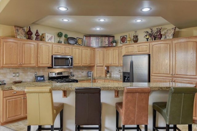 1511 N Lancashire Ln, Liberty Lake, WA 99019 - kitchen featuring recessed lighting, a kitchen breakfast bar, backsplash, light countertops, and appliances with stainless steel finishes