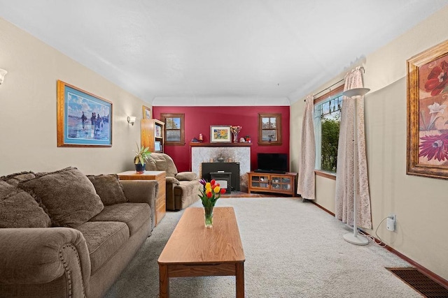 living area featuring a fireplace with flush hearth, visible vents, and carpet flooring