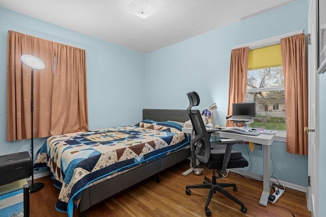 bedroom featuring baseboards and wood finished floors