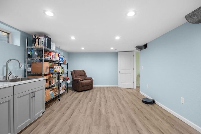 living area with baseboards, light wood-style floors, and recessed lighting