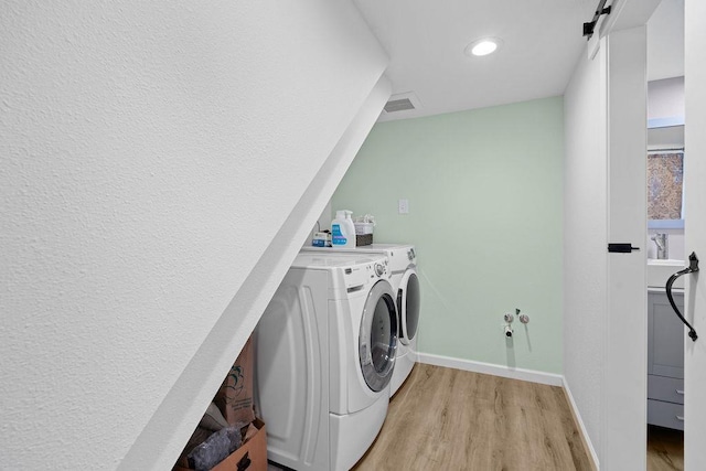 laundry area with recessed lighting, light wood finished floors, visible vents, washing machine and clothes dryer, and baseboards